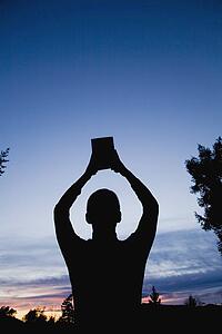 Man with Bible raised to the heavens