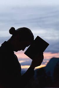 Silhouette of woman with a book