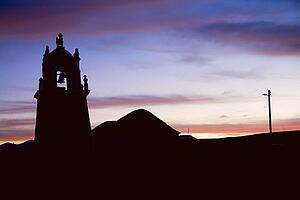 Silhouette of bell tower in Chipaya, Bolivia at sunset