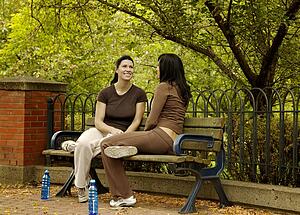 Two women sitting on park bench