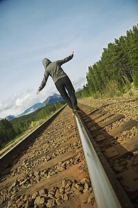 Woman walking on railroad track