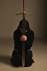 Person kneeling with a sword