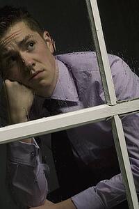 Unhappy man looking out a window