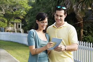 Mid-adult Caucasian couple holding a map and smiling.