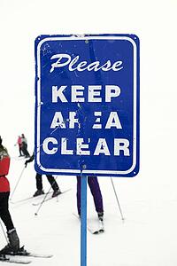 Sign at ski slope requesting area be kept clear.