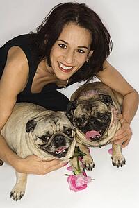 Caucasian female prime adult with two Pug dogs.