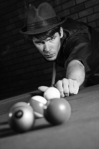 Prime adult Caucasian retro male shooting pool.