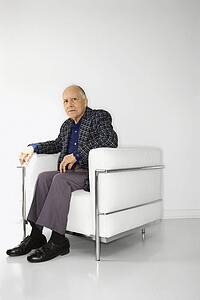 Caucasian mature adult male sitting in chair looking at viewer.