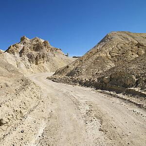 Dirt road through barren landscape in Death Valley National Park.