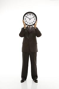 Caucasian middle-aged businessman holding clocks in front of their heads standing against white background.