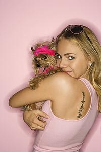 Caucasian young adult female holding Yorkshire Terrier dog.