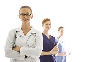 Portrait of smiling Caucasian medical healthcare workers in uniforms standing against white background.