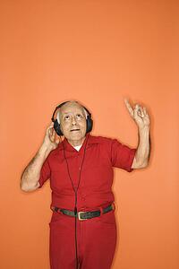 Mature adult Caucasian male listening to headphones.