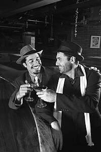Caucasian prime adult retro males sitting at bar drinking.