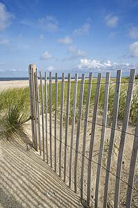Weathered wooden fence on sand dune.