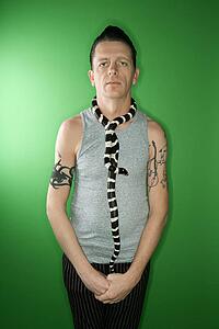 California Kingsnake draped around Caucasian mid-adult male's neck.