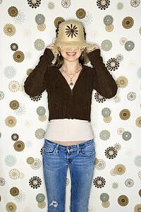 Caucasian adolescent female pulling hat over eyes.