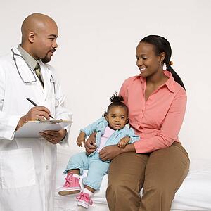 African-American mother and baby girl with male pediatrician. 