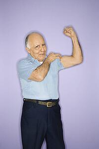 Caucasian mature adult male flexing muscles.