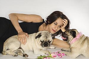 Caucasian prime adult female with two Pug dogs.