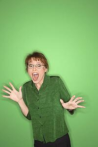 Smiling Caucasian mid-adult woman gesturing on green background.