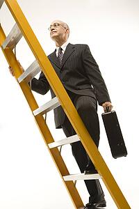 Caucasian middle-aged businessman climbing ladder carrying briefcase.