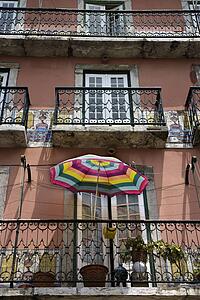 Building with balconies and colorful umbrella in Lisbon, Portugal.