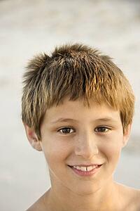 Portrait of smiling Caucasian pre-teen boy on beach.