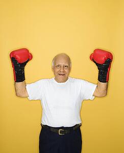 Caucasian mature adult male wearing boxing gloves.