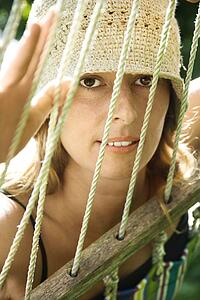 Caucasian mid-adult woman looking through hammock.