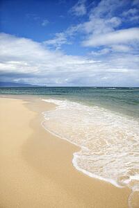 Tropical beach with wave receding from shore in Maui Hawaii, USA