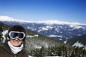Caucasian middle-aged woman skier posing on mountain.