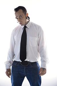 Caucasian mid-adult man with tattoos and piercings.