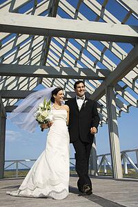 Caucasian mid-adult bride and groom walking together.