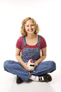 Caucasian mid-adult woman holding Old English Bantam Rooster wearing bow tie.