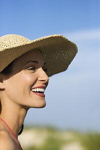 Caucasian mid-adult female in swimsuit and straw hat.