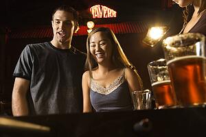 Young couple teamed up at foosball game in pub.