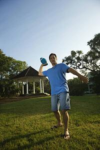 Caucasian mid-adult man throwing football.