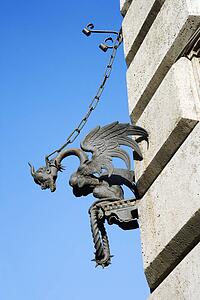 Winged gargoyle chained to wall.