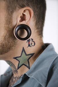 Caucasian mid-adult man with tattoos and piercings.