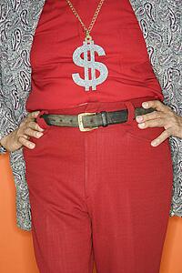 Mature adult Caucasian male wearing money sign necklace.