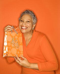 African American mature adult female holding gift bag.
