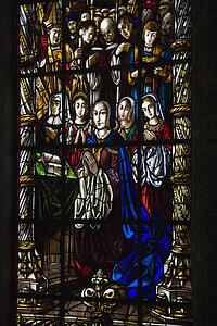 Sunlit religious themed stained glass window in Jeronimos Monastery in Lisbon, Portugal.