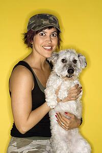Hispanic mid-adult woman female holding small white dog.