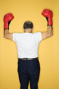 Caucasian mature adult male wearing boxing gloves.