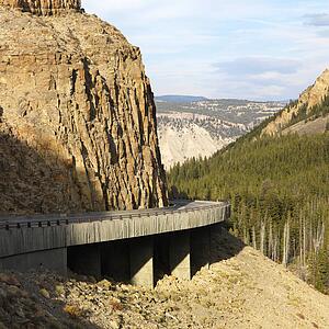 Highway winding through steep Wyoming mountains.