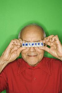 Mature adult Caucasian male holding pill organizer.