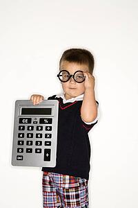 Caucasian male child wearing glasses and holding large calculator.