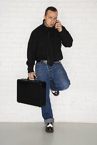 Caucasian mid-adult man with tattoos and piercings talking on cell phone.