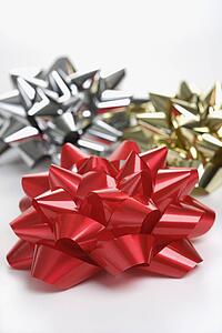 Still life of big shiny red, gold and silver Christmas bows.